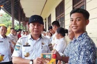 BANTUAN : Pj Bupati Katingan Sutoyo secara simbolis memberikan bantuan kepada peserta didik di SMP Negeri 6 Katingan Hilir. (foto:rul)