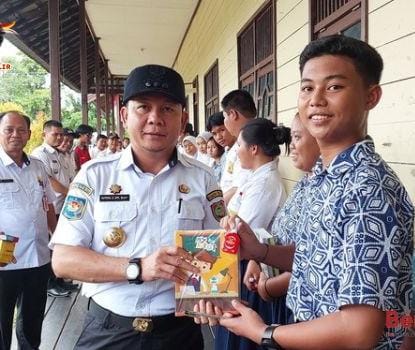 BANTUAN : Pj Bupati Katingan Sutoyo secara simbolis memberikan bantuan kepada peserta didik di SMP Negeri 6 Katingan Hilir. (foto:rul)
