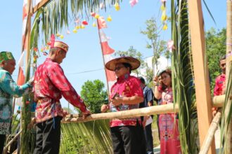 PENCANGAN : Asisten Bidang Pemerintahan dan Kesejahteraan Rakyat Sekretariat Daerah Kabupaten Katingan, George Heplin Edwar Doddy memotong pantan pada acara pencanangan Desa Cantik di Desa Banut Kalanaman, Kamis (19/9/2024). (foto:saleh)