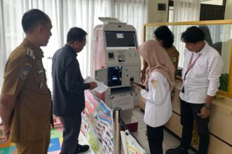 Ketua DPRD Palangka Raya, Subandi melihat cara kerja mesin ADM di Kantor Kecamatan Pahandut (Foto Ist)