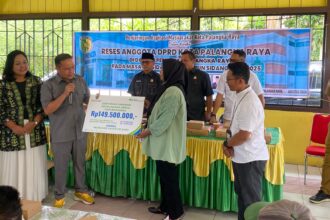 Anggota DPRD Kota Palangka Raya, Khemal Nasery saat menyerahkan secara simbolis manfaat BPJS Ketenagakerjaan kepada salah satu warga Kelurahan Marang (Foto : Ist)
