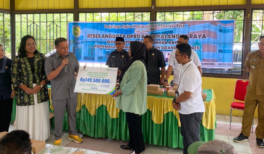 Anggota DPRD Kota Palangka Raya, Khemal Nasery saat menyerahkan secara simbolis manfaat BPJS Ketenagakerjaan kepada salah satu warga Kelurahan Marang (Foto : Ist)