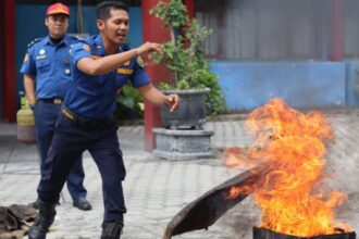 Personel Damkar Palangka Raya saat memberikan contoh memadamkan api menggunakan karung goni basah (Foto : Ist)
