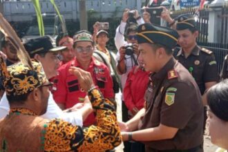 Bupati Barito Utara, Shalahuddin saat menyambut kedatangan Kejari Barito Utara Fredy Feronico Simanjuntak, dengan upacara tradisi adat potong Hompong (Foto : Ist)