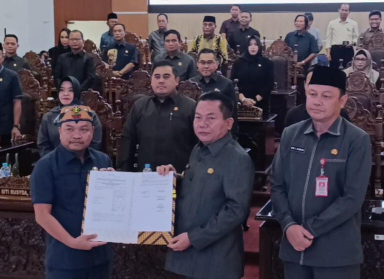 Bupati Kapuas, Muhammad Wiyatno, menerima hasil persetujuan terhadap enam buah Raperda dari Wakil Ketua II DPRD Kabupaten Kapuas, Berinto (Foto : Ist)