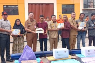 Bupati Kapuas, Muhammad Wiyatno dan Wabup Dodo menyerahkan bantuan kepada sepuluh korban kebakaran di halaman Kantor BPBD Kabupaten Kapuas (Foto : Ist)