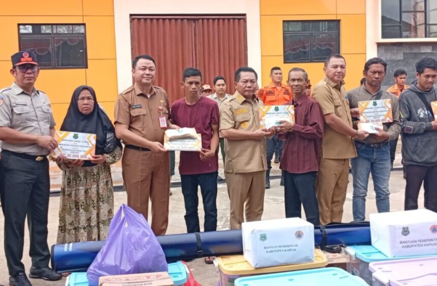 Bupati Kapuas, Muhammad Wiyatno dan Wabup Dodo menyerahkan bantuan kepada sepuluh korban kebakaran di halaman Kantor BPBD Kabupaten Kapuas (Foto : Ist)